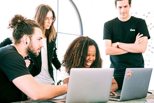 Quality in Agile: Coworkers collaborating around a computer